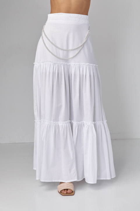 Длинная юбка с оборками украшена ожерельем из жемчуга